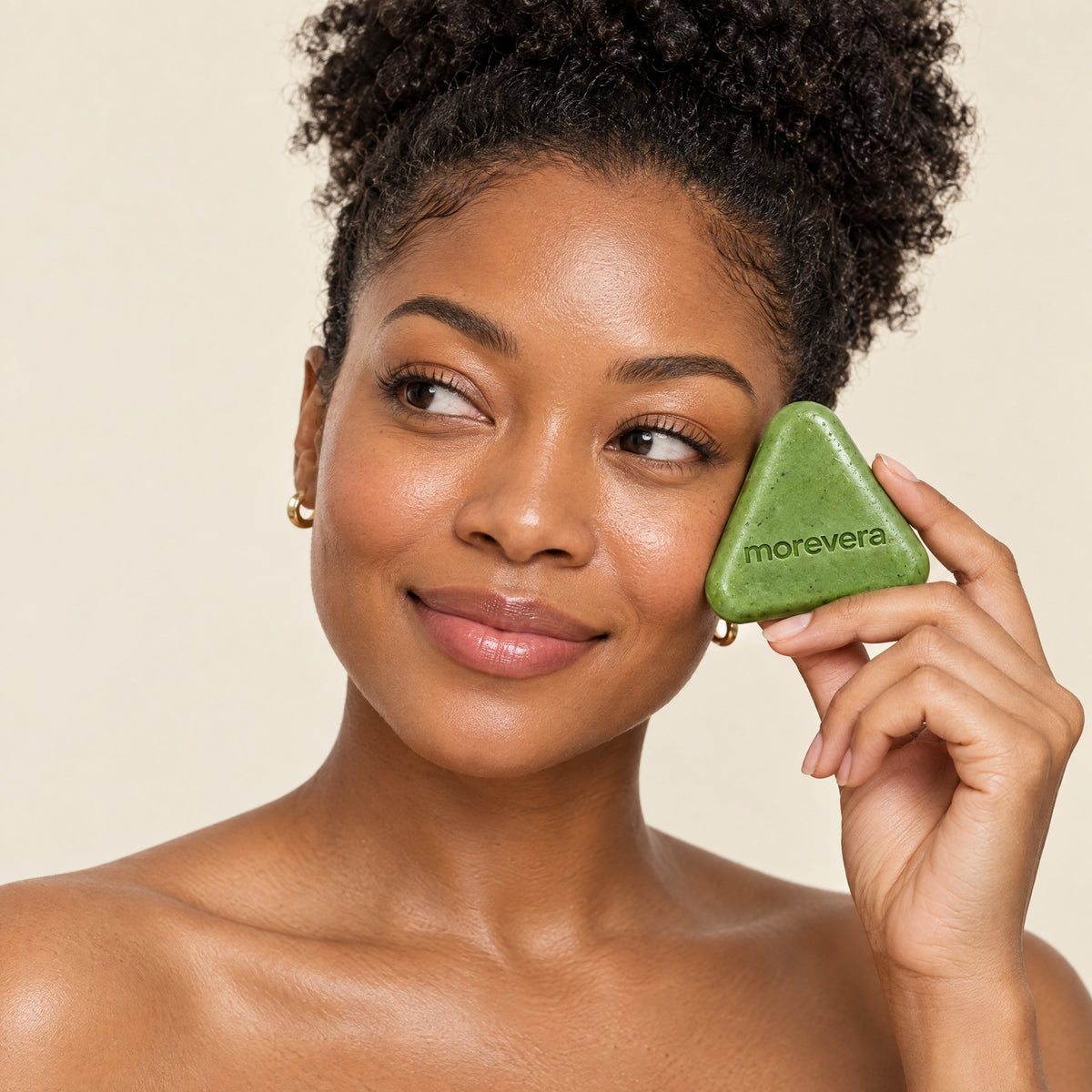Woman with natural coily hair holding the scalp bar near her hairline